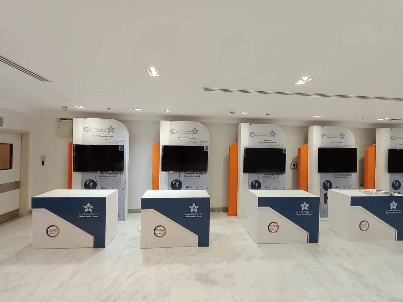 صف من الكاونترات المتماثلة أمام خلفيات تعريفية بشاشات