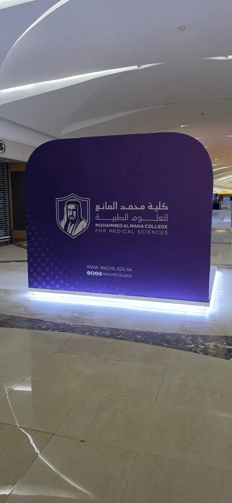 خلفية تعريفية منحنية لكلية محمد المانع للعلوم الطبية بإضاءة سفلية